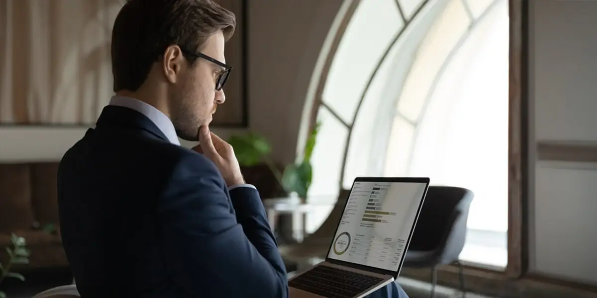 Ragazzo che consulta da un computer contenuti di economia e finanza, mostrando interesse verso la tematica.